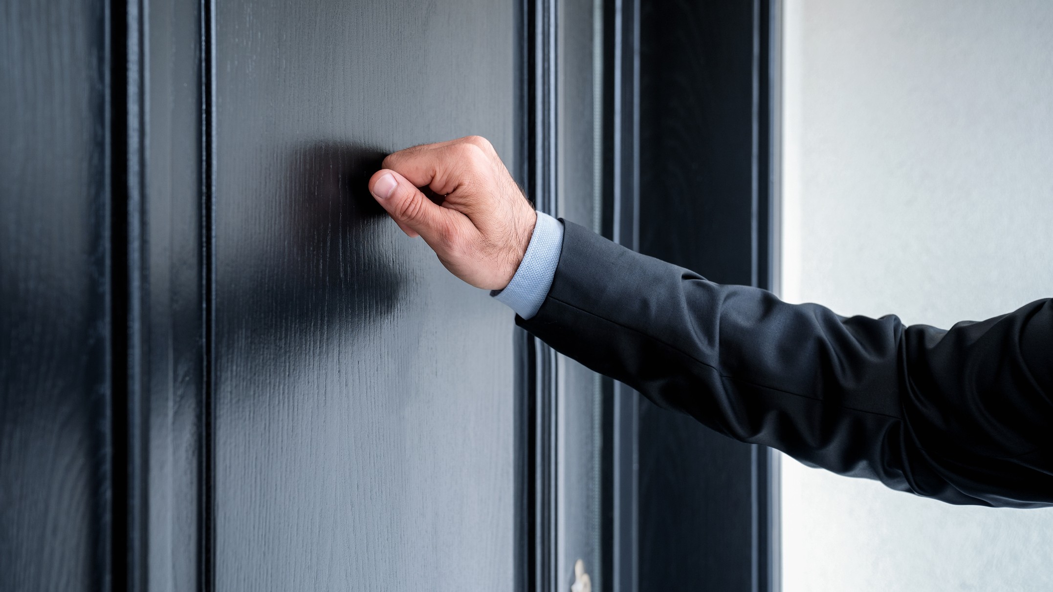 A man in a formal suit knocks on a blue door, representing institutional finance seeking entry to the retail market.