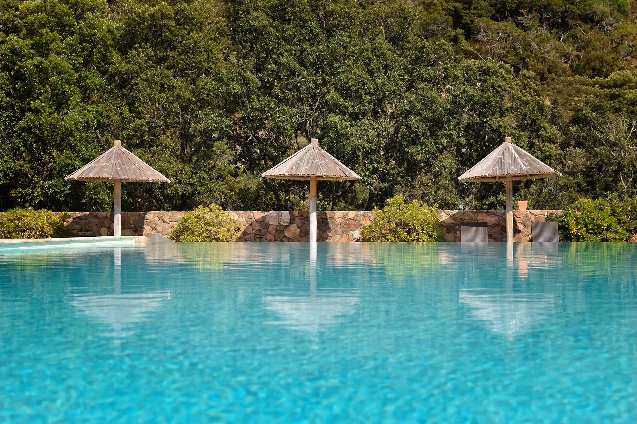 An expansive luxury resort pool at sunset representing Fine Hotels and Resorts benefits.
