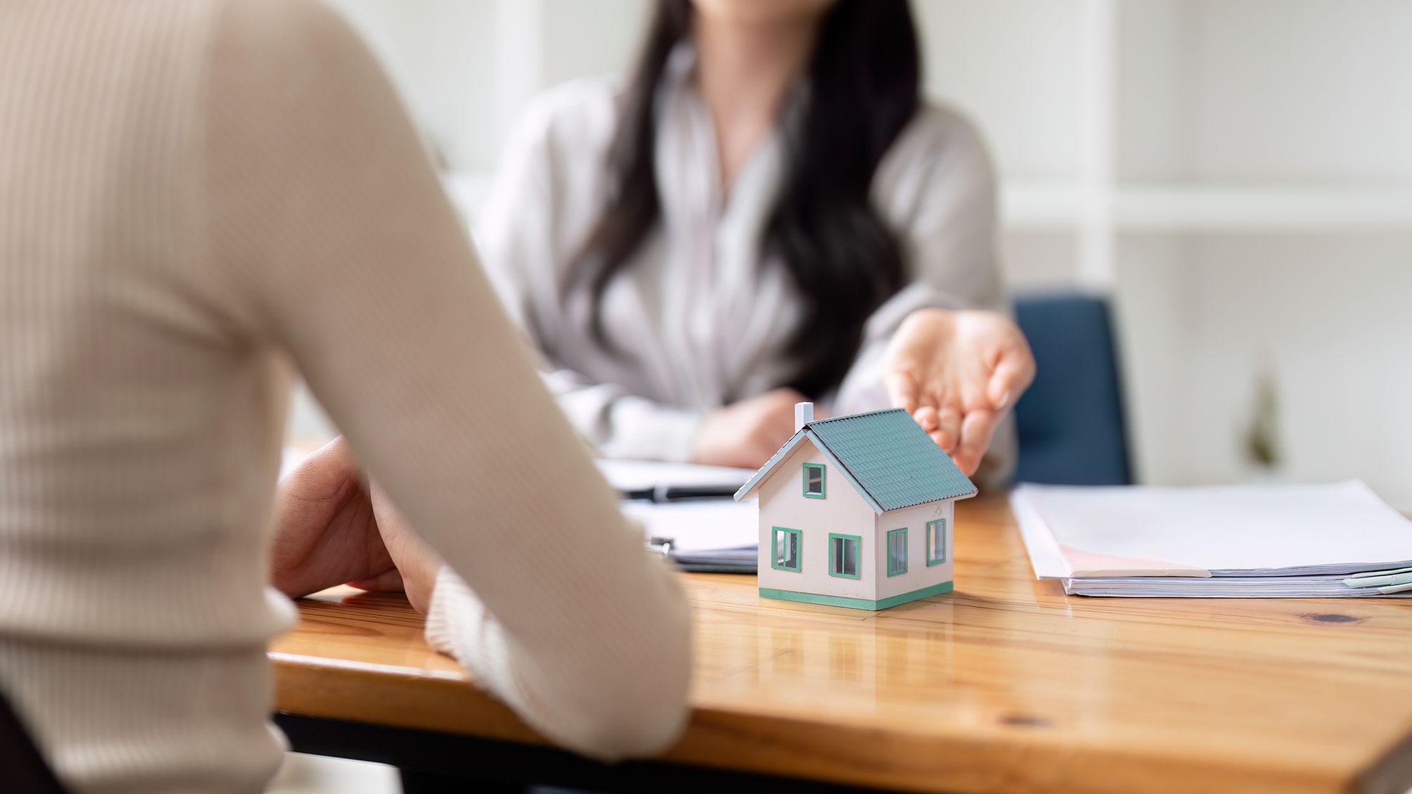 A professional real estate agent explaining a mortgage contract to a client.