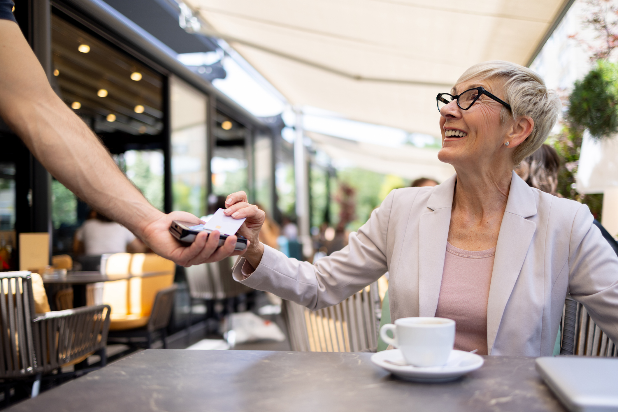 A close-up of a consumer using a credit card for a contactless payment