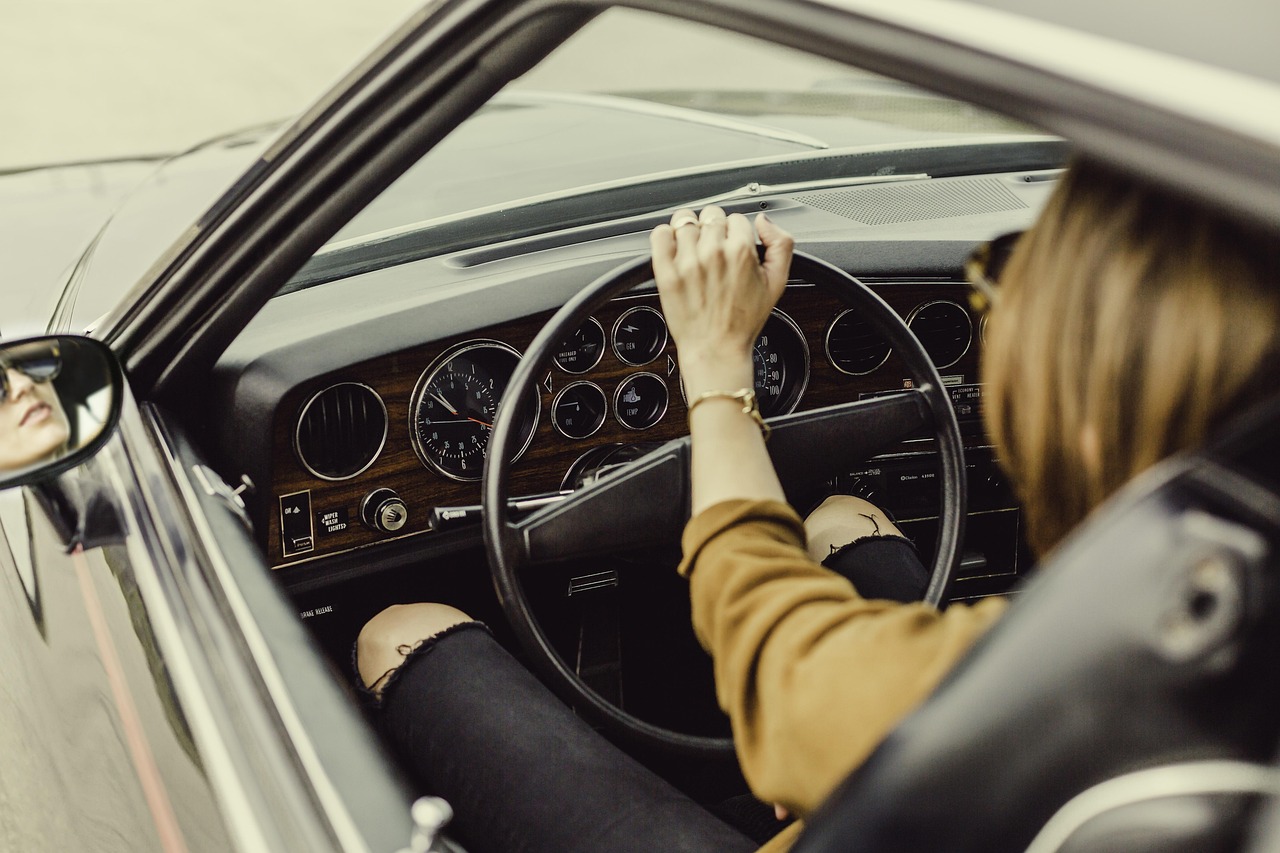 A person holding car keys inside a modern vehicle, signifying ownership and control.