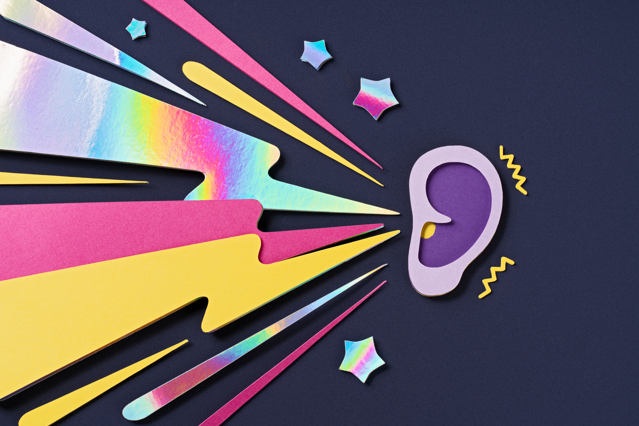 Paper craft lightning bolts hitting a purple ear, representing loud market noise and social media impulses.