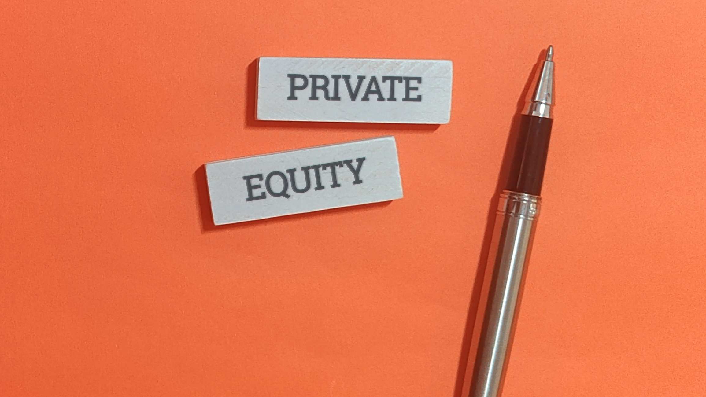 Close-up of the words 'private equity' written on a document next to an orange background.