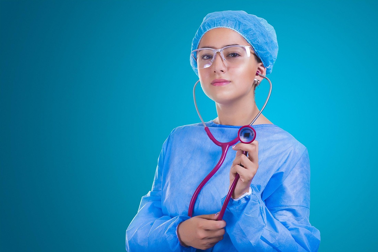 A stethoscope lying on top of a detailed hospital invoice and a calculator.