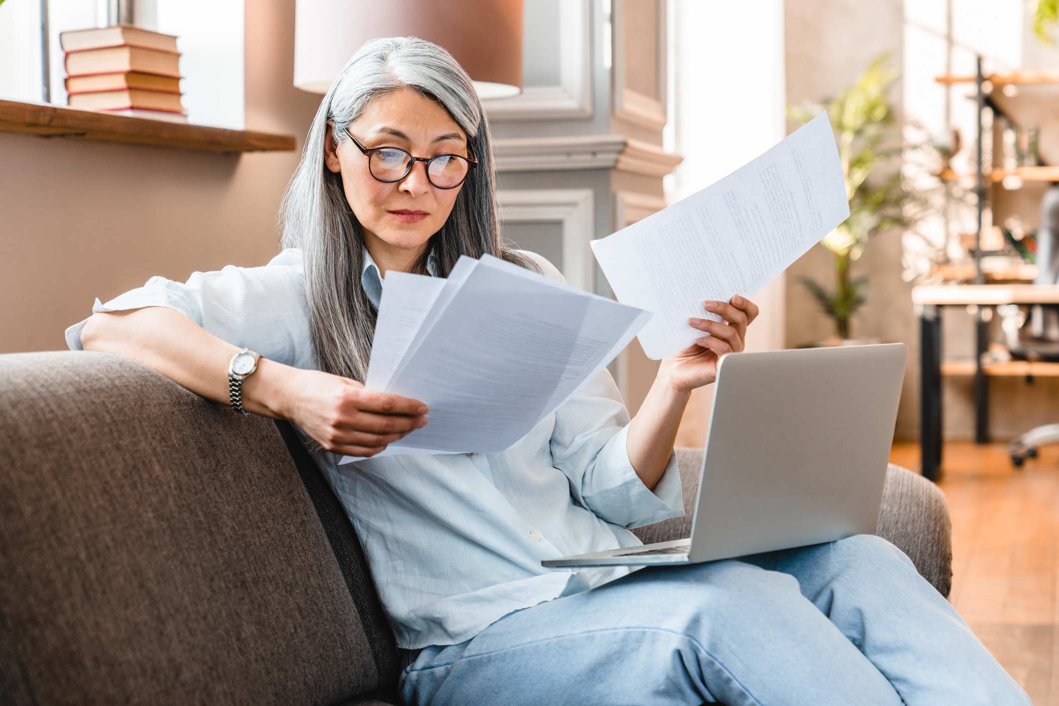 A woman closely examining the details of a printed contract.