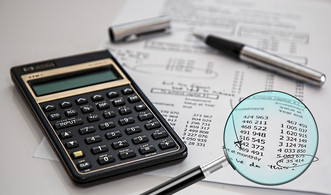 A magnifying glass focusing on text in a financial contract or legal document.