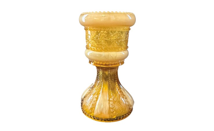 An antique custard glass toothpick holder with intricate patterns.