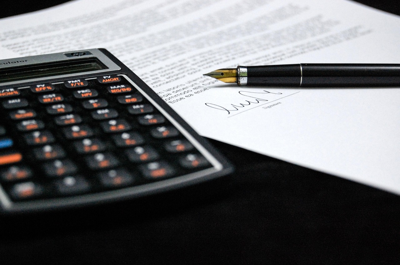A close-up of a hand signing a legal document with a fountain pen.
