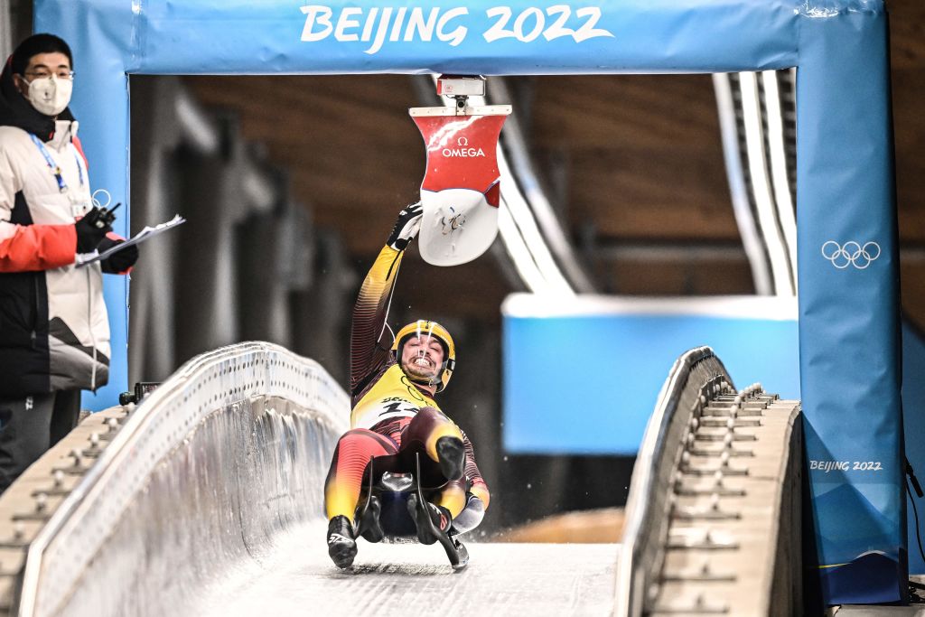 A luge athlete speed down an icy track during a professional winter sports competition