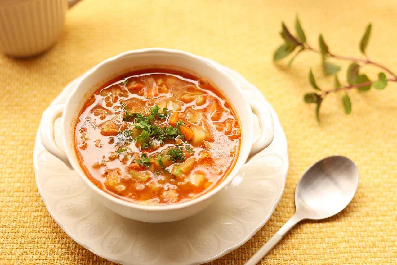 A warm bowl of lentil soup served with a slice of bread.