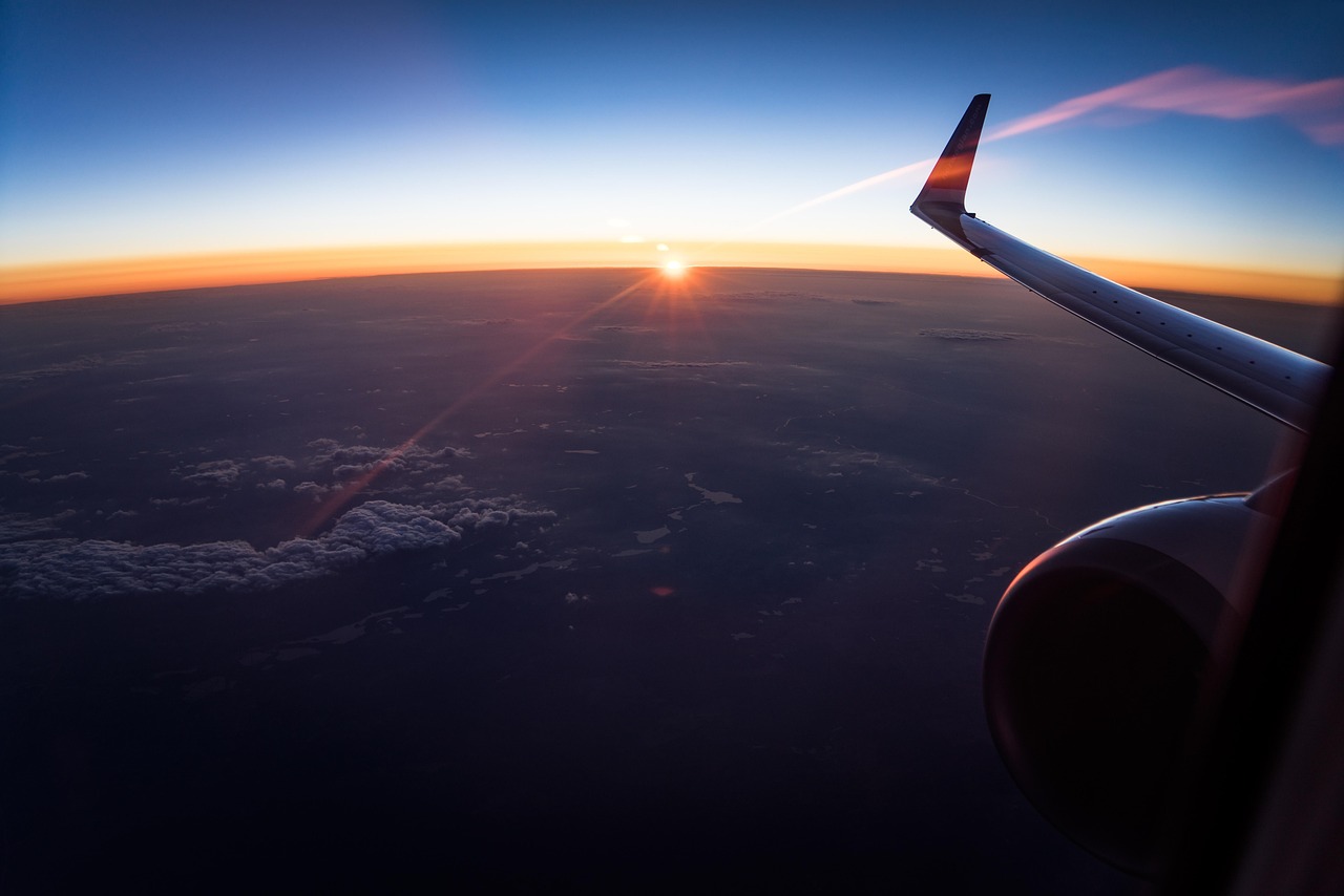 View of an airplane wing from a luxury cabin window during sunset