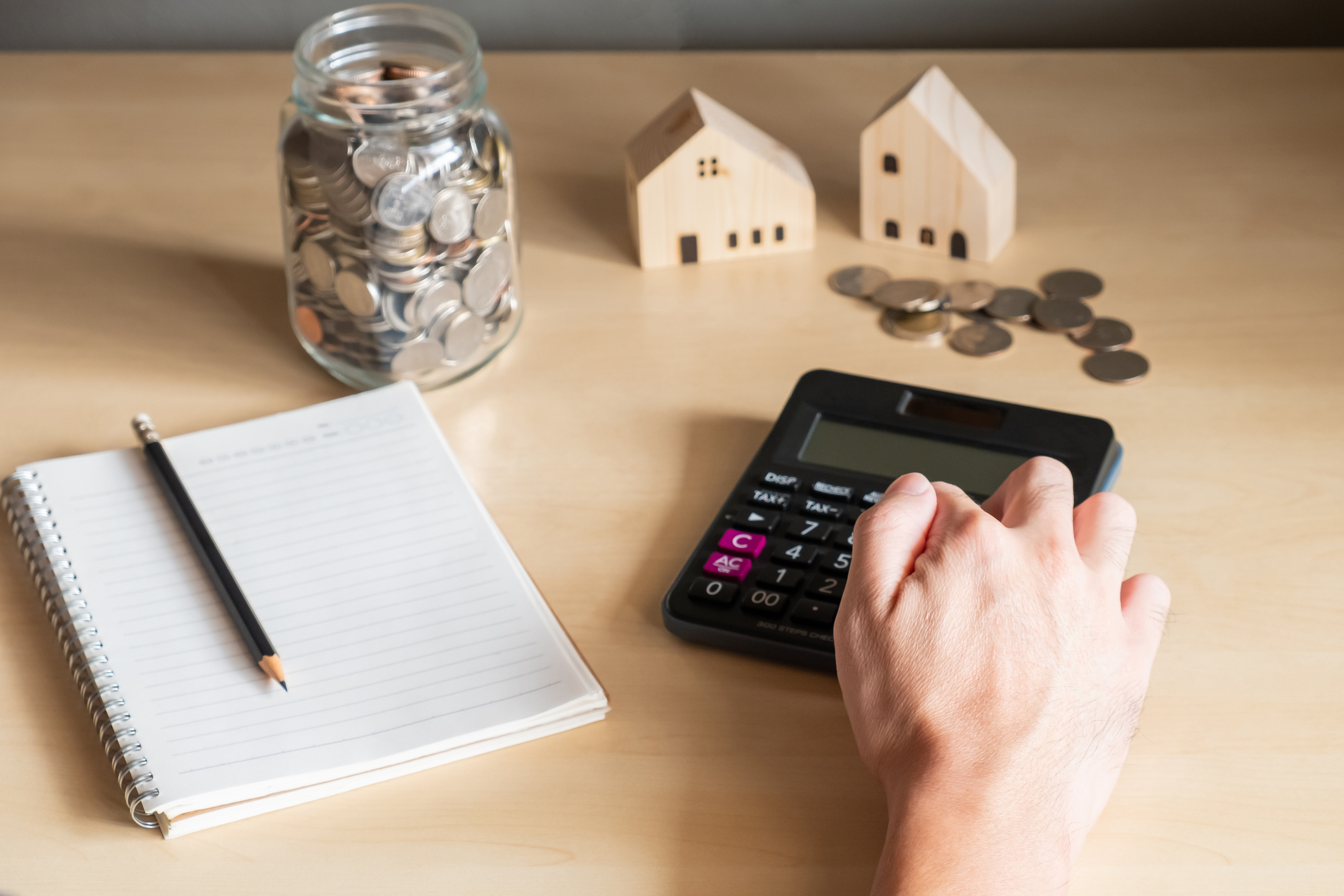 Close-up of a person's hand using a calculator to figure out a budget or savings plan.
