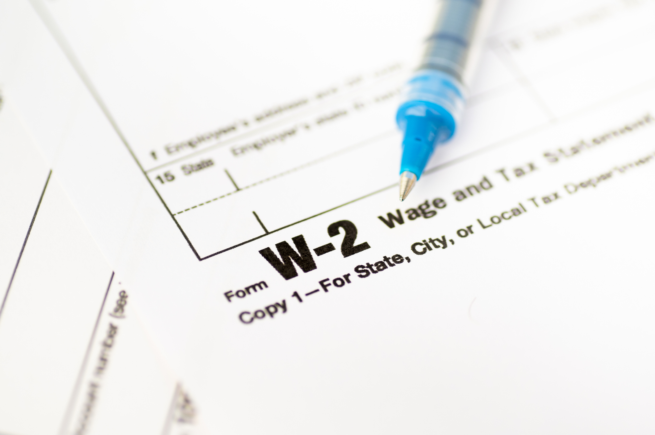 A pen resting on a Wage and Tax Statement Form W-2.