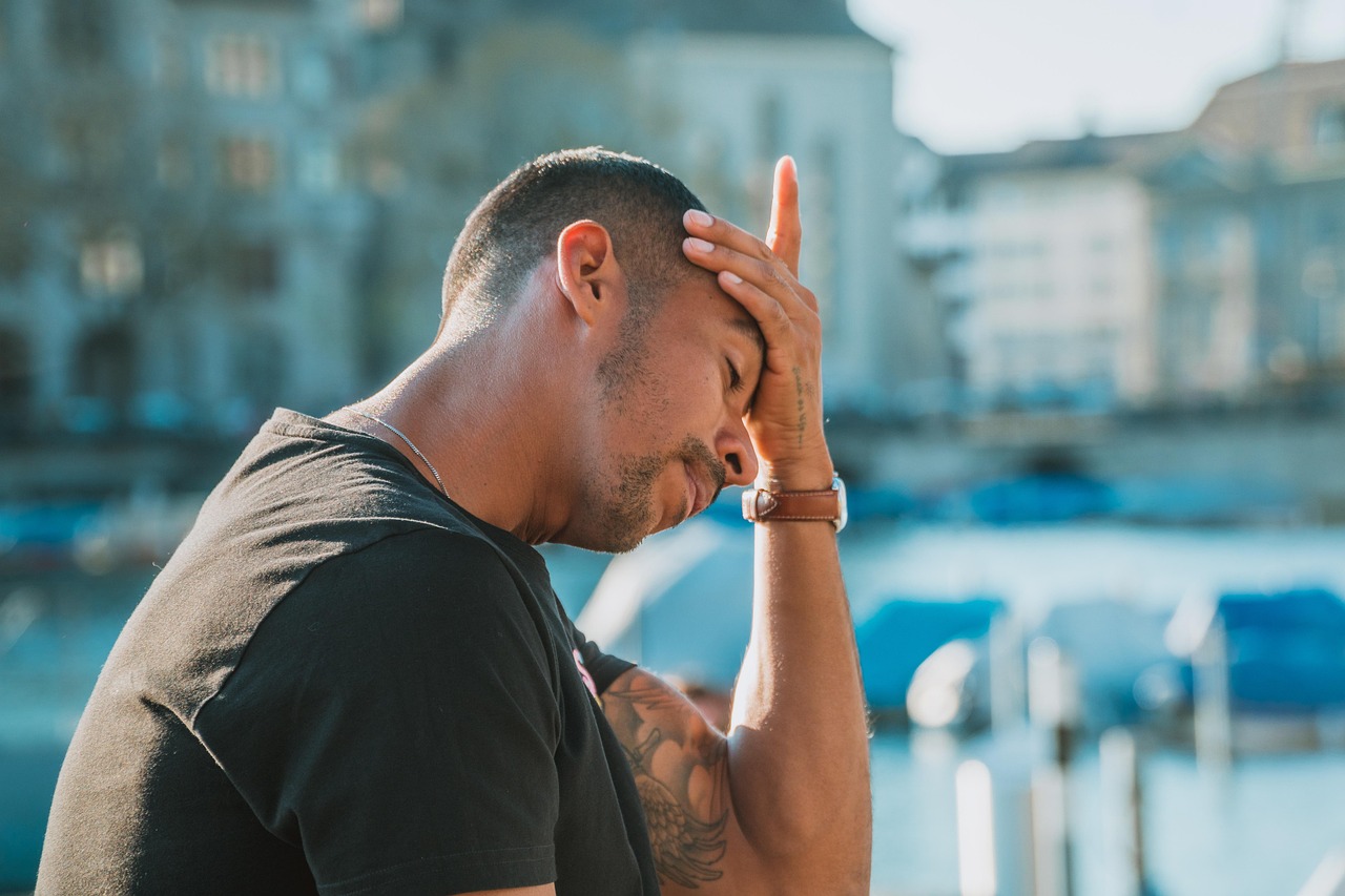 A person looking stressed while reviewing financial documents at a desk