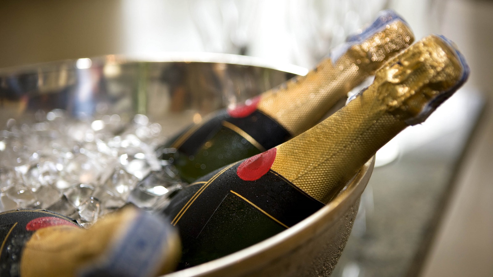 Two bottles of champagne cooling in a bucket of ice.