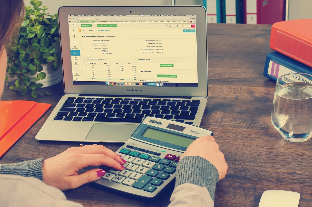 A professional calculator resting on detailed financial documents and tax forms.
