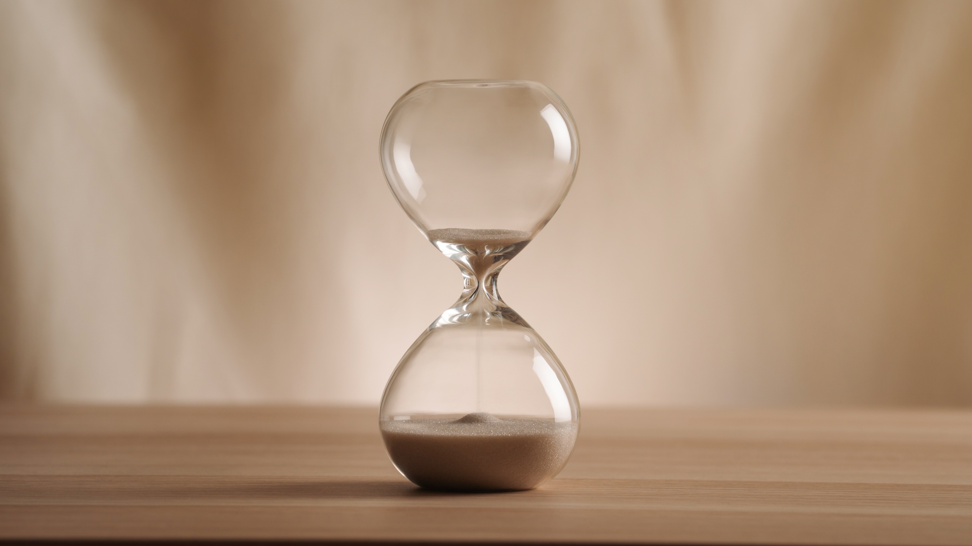 An hourglass with sand running out, symbolizing a deadline.