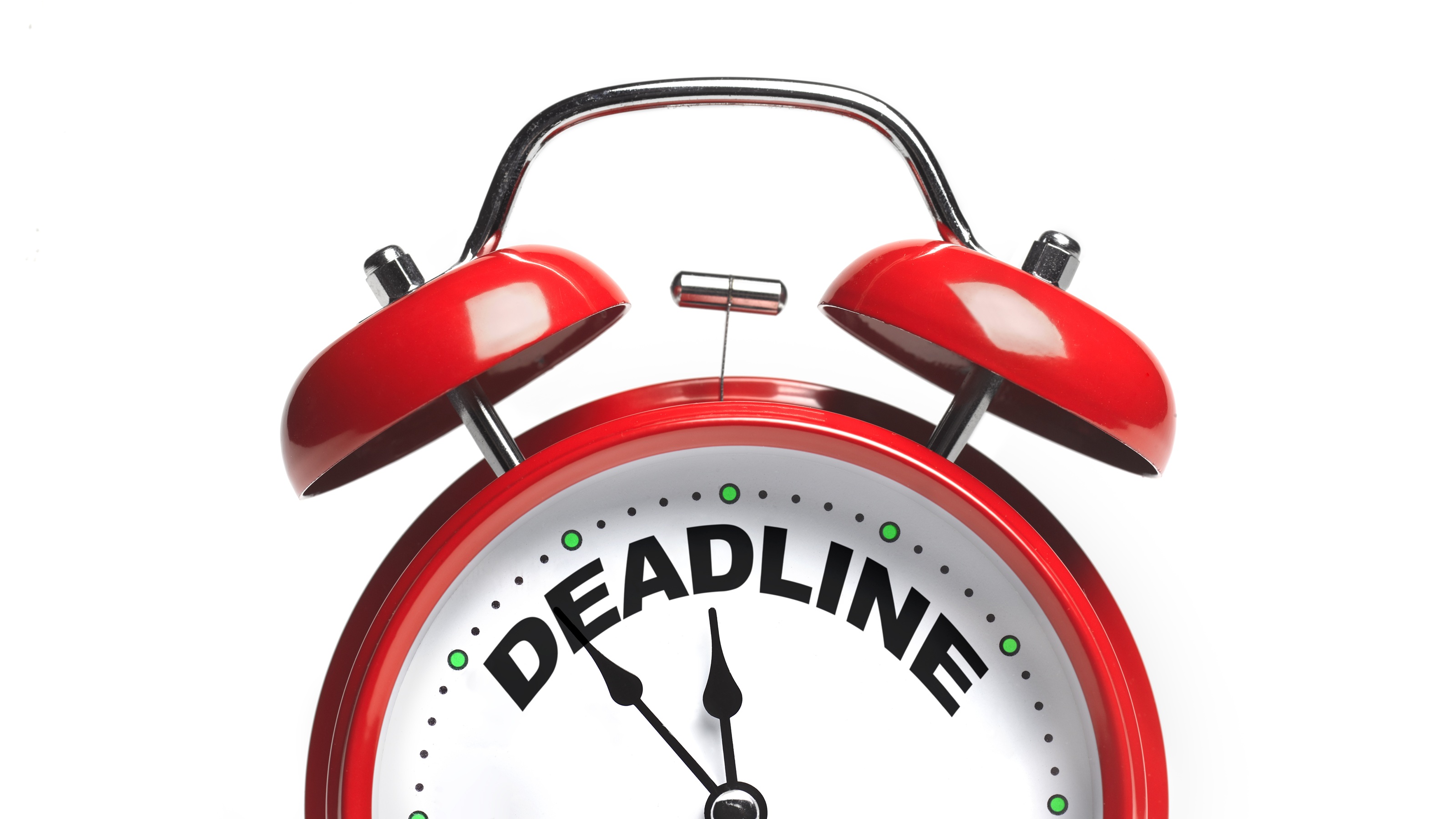 A red alarm clock with the word 'deadline' on it, symbolizing the end of the tax year.